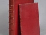 two red books sitting next to each other on a gray surface