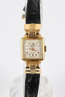 une photo d'une montre-bracelet plaquée or avec un bracelet en cuir noir