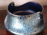a blue and silver vase sitting on a wooden table