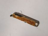 a small pocket knife with a wooden handle on a white surface