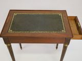 an old wooden table with a leather top and a drawer