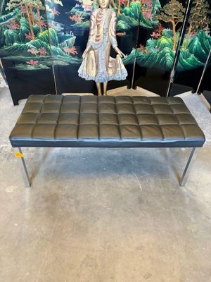 un banc sur lequel se trouve une statue, devant un écran