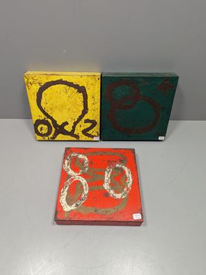 trois tableaux exposés sur une table
