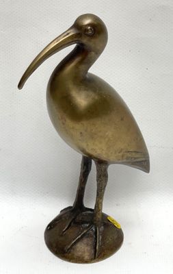 brass statue of a bird with a long beak on a white background
