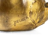 a gold vase with a bird on it on a white surface