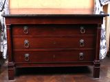 a wooden dresser with a marble top on a wooden floor