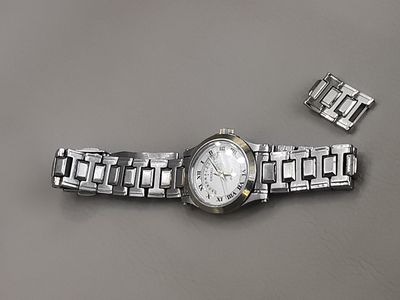 une montre posée sur une table à côté d'un bracelet