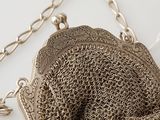 an antique silver chainmail purse with a chain around the clasp