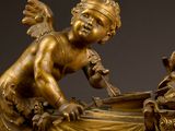 bronze statue of an angel with a baby in a crib