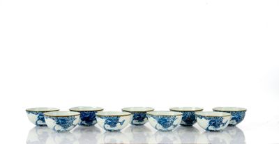 Plusieurs bols et tasses bleus et blancs sont alignés sur une surface blanche