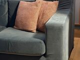 a blue couch with two pillows on it in a living room