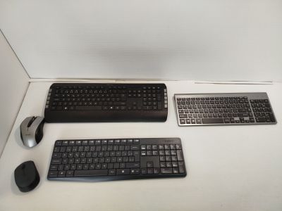 two keyboards and a mouse sitting on a desk