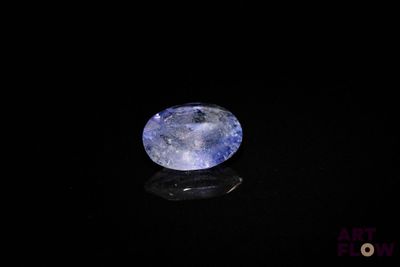 an oval blue sapphire stone on a black surface
