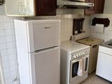 a small kitchen with a refrigerator, stove, and sink