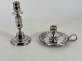 pair of silver plated candlesticks on a saucer and saucer