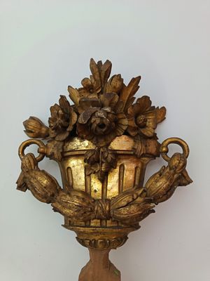 a gold vase with flowers on it on a table
