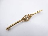 a close up of a gold hair pin with a flower on it