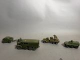 several toy army vehicles are lined up in a row on a white surface