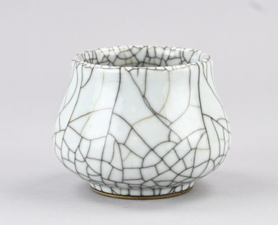 un vase en verre craquelé blanc et noir posé sur une table