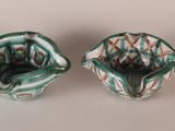 pair of small green and white ceramic bowls with designs on them
