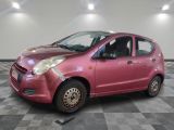 une photo d'une petite voiture rose garée dans un garage