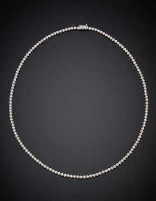 a pearl necklace with a diamond clasp on a black background