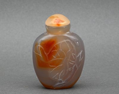 un vase en verre orné d'une fleur, posé sur une surface grise
