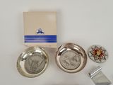 several silver metal items are sitting on a white surface
