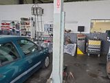 une voiture bleue garée dans un garage à côté d'un poteau