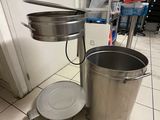 une casserole et une poêle posées par terre dans une cuisine