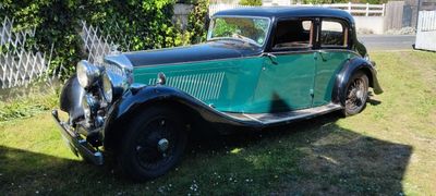 une voiture verte garée dans l'herbe