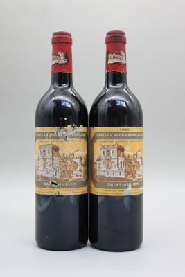 deux bouteilles de vin rouge posées l'une à côté de l'autre sur une surface blanche