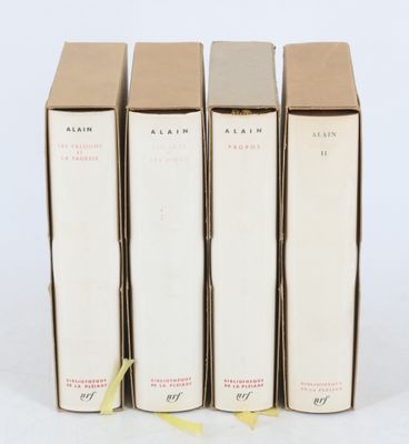 trois livres sont empilés sur une surface blanche