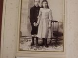 an old picture of a young boy and girl standing next to each other