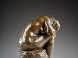 a bronze statue of a man with his head in his hands