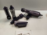 a hair dryer, comb, and other items on a table