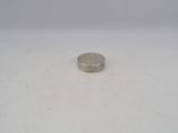 a small silver coin sitting on top of a white surface