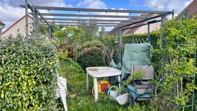 une petite terrasse avec une table et des chaises dans le jardin