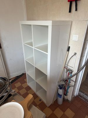 a white bookcase in the corner of a room