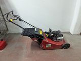 a red lawn mower that is sitting on the ground