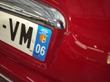 a close up of a license plate on the back of a red car