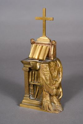 statue of a woman sitting at a desk with a cross on top of it