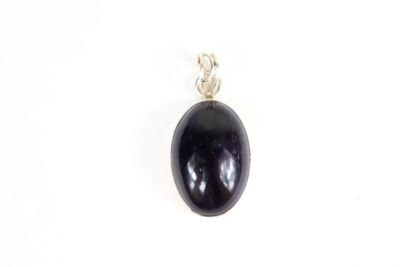 un pendentif en pierre noire muni d'une bélière en argent, sur fond blanc