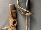 an old sword with a leather sheath on a gray surface