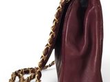 burgundy leather handbag with gold chain strap on a white background
