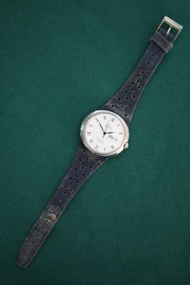 an image of a watch sitting on top of a green surface
