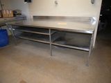 a large stainless steel work table in the middle of a room