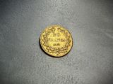 a close up of a gold coin on a gray surface