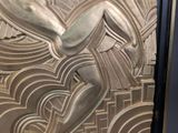 an art deco sculpture of a woman holding a surfboard