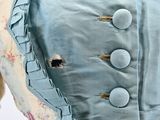 a blue dress with buttons on the back of it